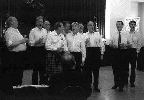 Picture of men singing "my love she's but a lassie yet"